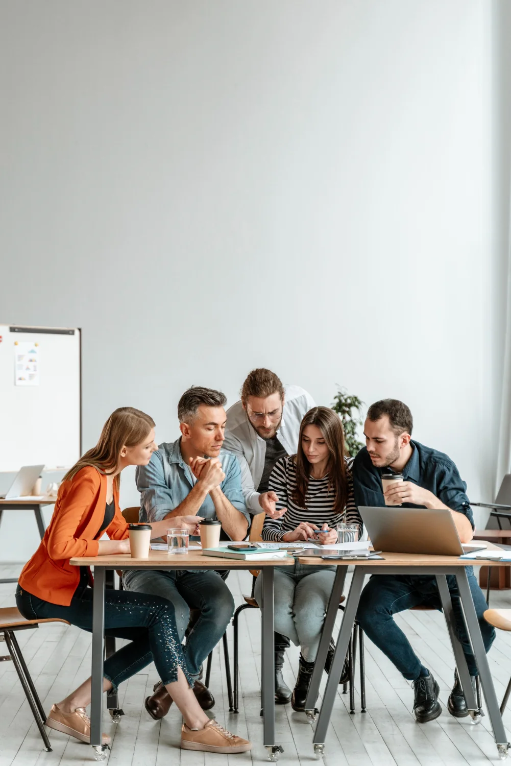A team reviewing their work together around a laptop